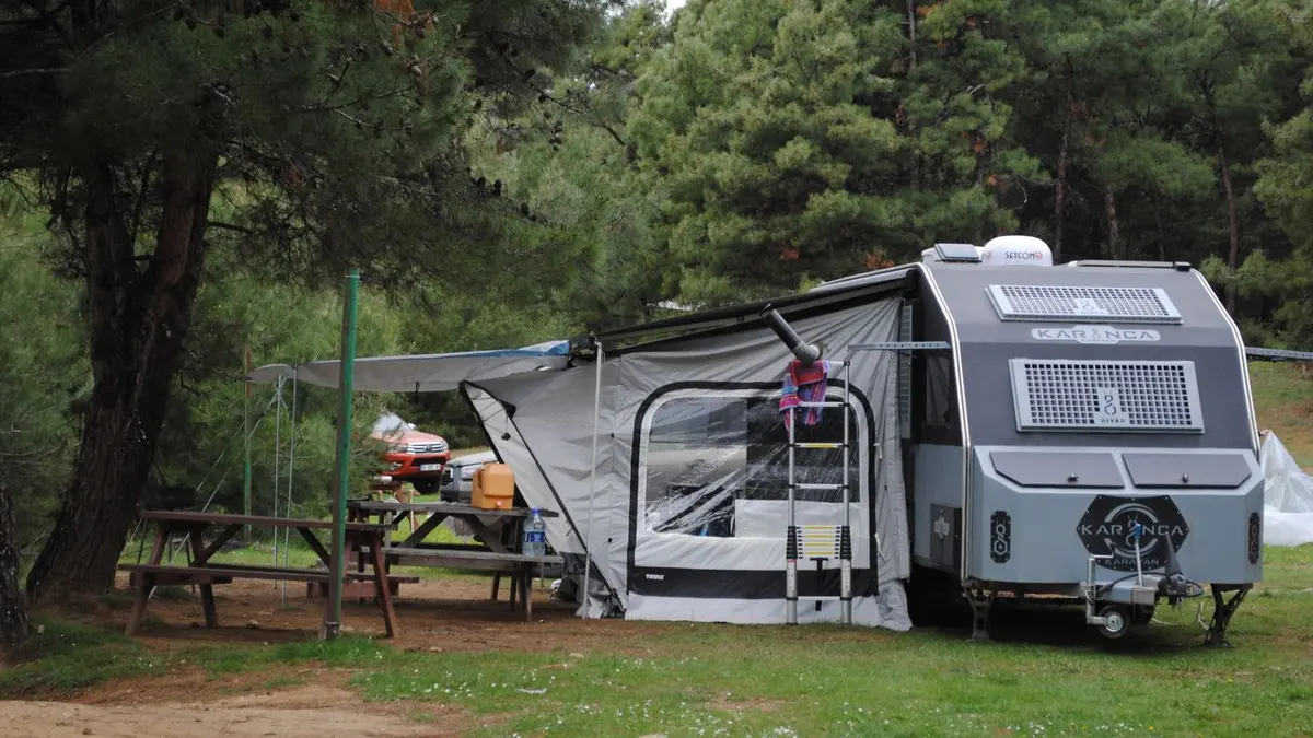 Caravane aménagée stationnée sur une aire, assurance professionnelle pour gens du voyage
